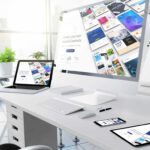Moderne Büroumgebung mit mehreren Geräten, die responsive Webdesigns anzeigen, illustriert die Vielseitigkeit und Anpassungsfähigkeit.