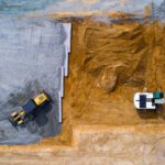 Drohnenaufnahme einer Baustelle mit Bagger und Planierraupe, passend zum Webdesign für die nowiBAU Gruppe.