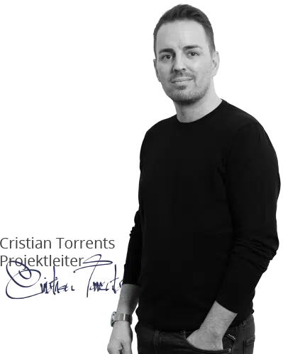 Ein Mann in schwarzem Pullover steht lächelnd mit einer Hand in der Hosentasche, passend zum Thema Webdesign auf der Startseite.